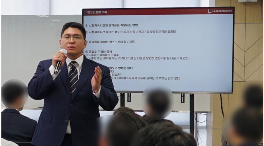 유튜브 알고리즘 강의 화면 앞에서 마이크를 들고 강의하는 대표